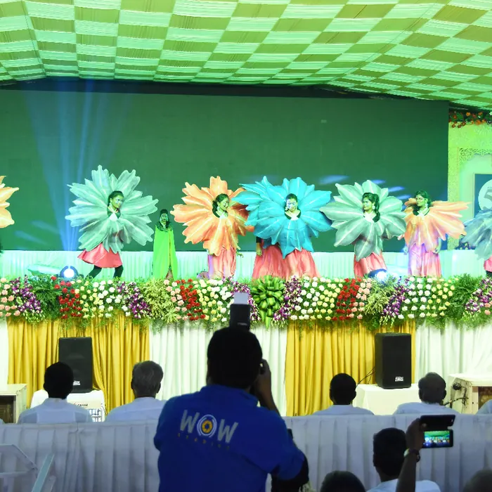 Themed floral costume performance on a decorated annual day stage